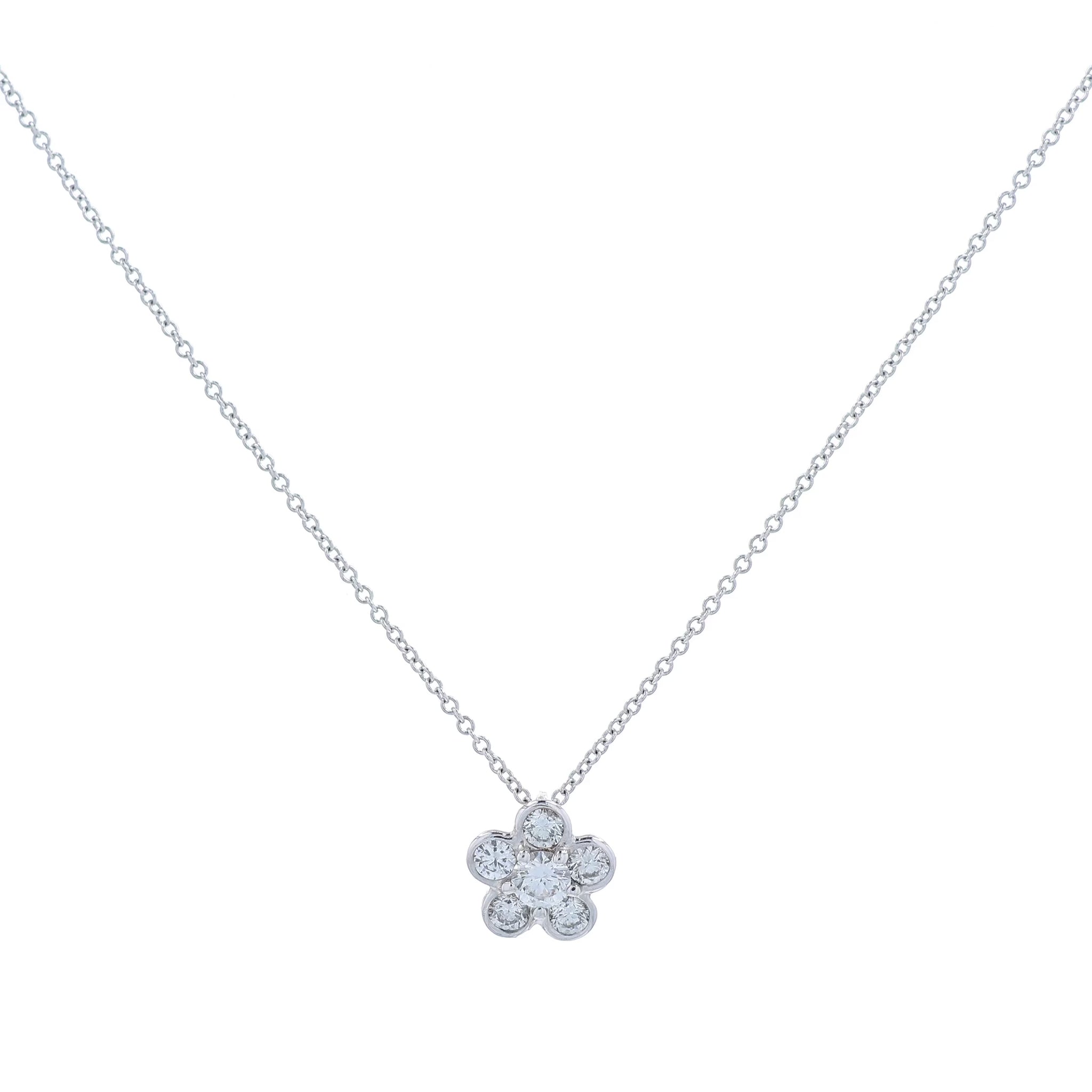 White gold flower shape diamond pendant necklace on a white background