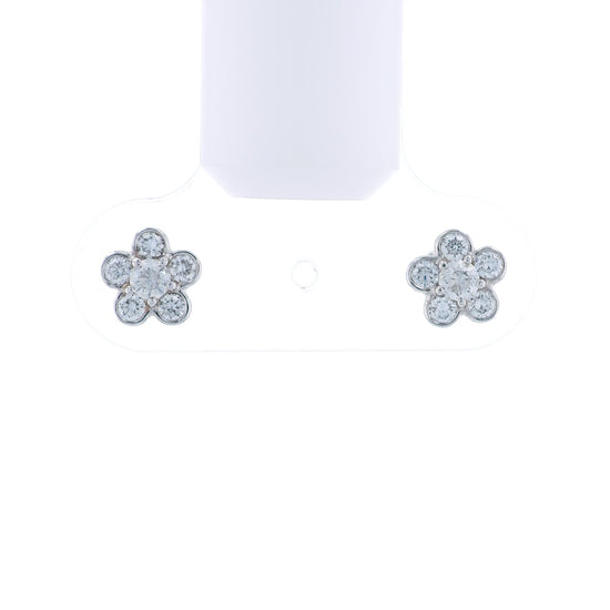 Flower-shaped white gold earrings with diamond accents on a white background