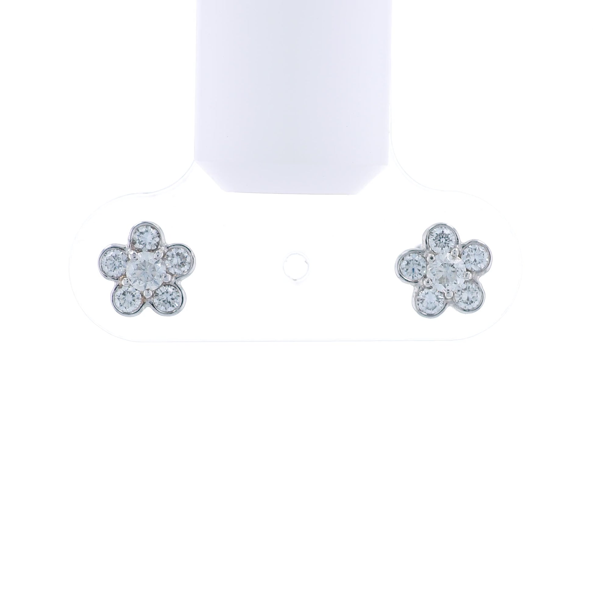 Flower-shaped white gold earrings with diamond accents on a white background