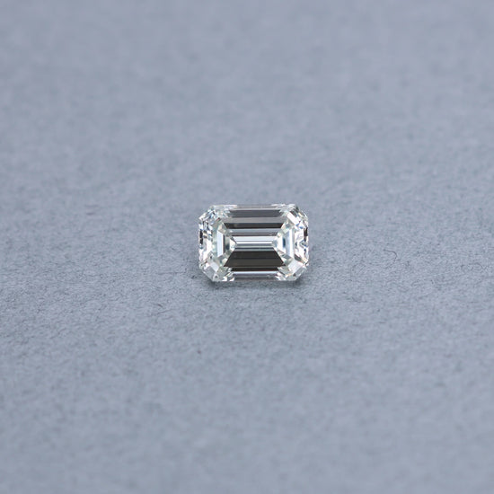 Emerald cut 3.00 carat GIA certified diamond graded JSI1 on a grey background
