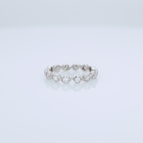 White gold ring with bezel set diamonds on a white background