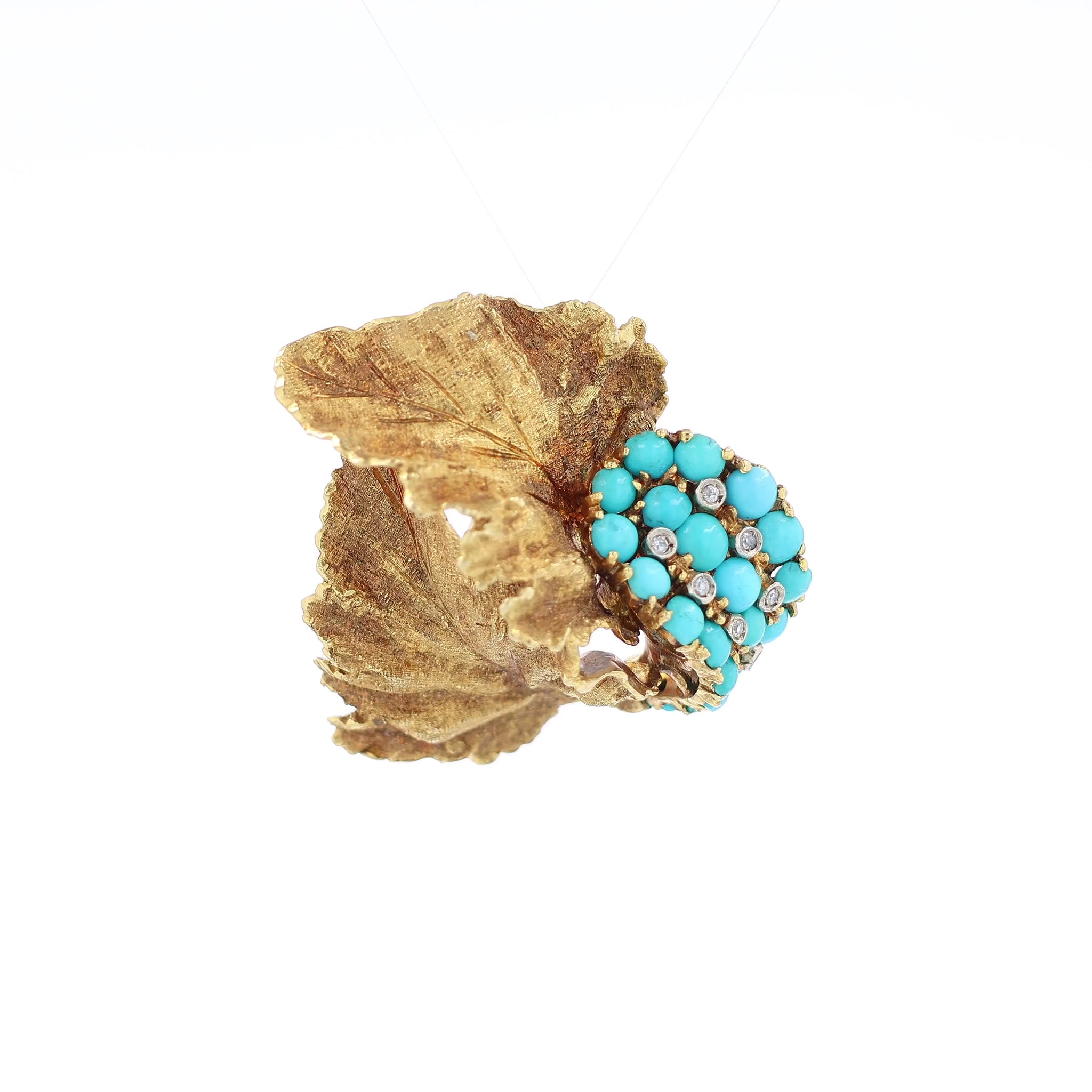 Yellow gold brushed leaf design turquoise and diamond pin on a white background