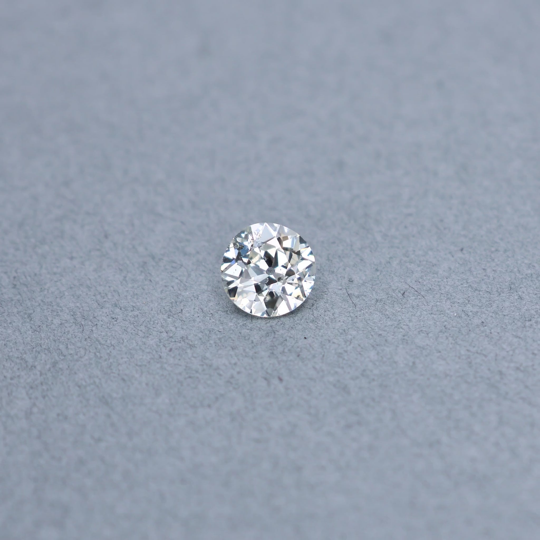 Old european 1.67 carat diamond graded KI1 on a grey background