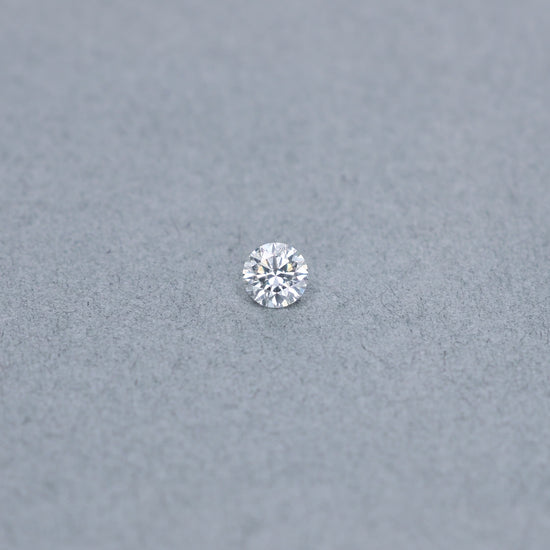 Round .56 carat triple excellent GIA certified diamond graded GSI1 on a grey background