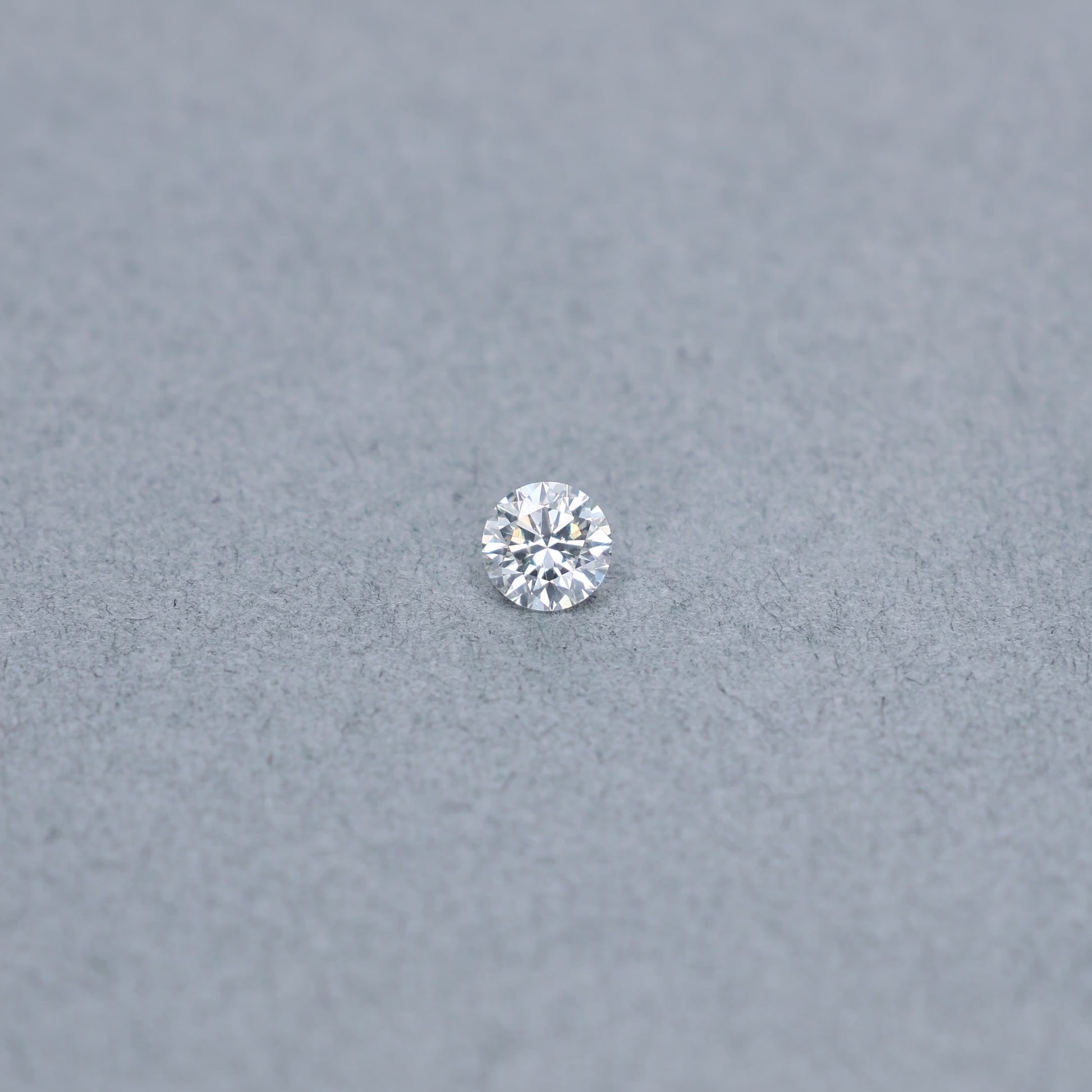 Round .56 carat triple excellent GIA certified diamond graded GSI1 on a grey background