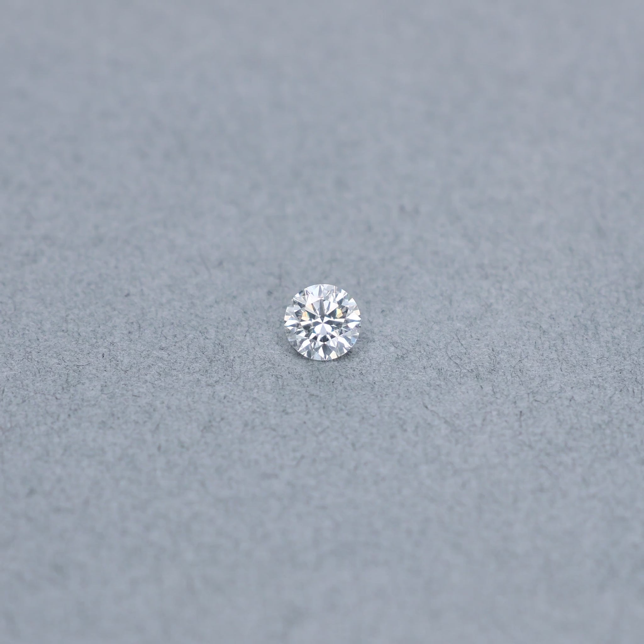 Round .56 carat triple excellent GIA certified diamond graded GSI1 on a grey background