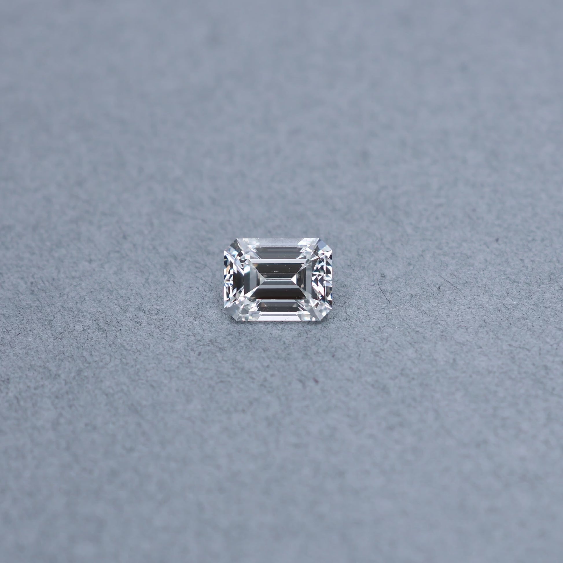 Emerald cut 2.02 carat GIA certified diamond graded EVS2 on a grey background