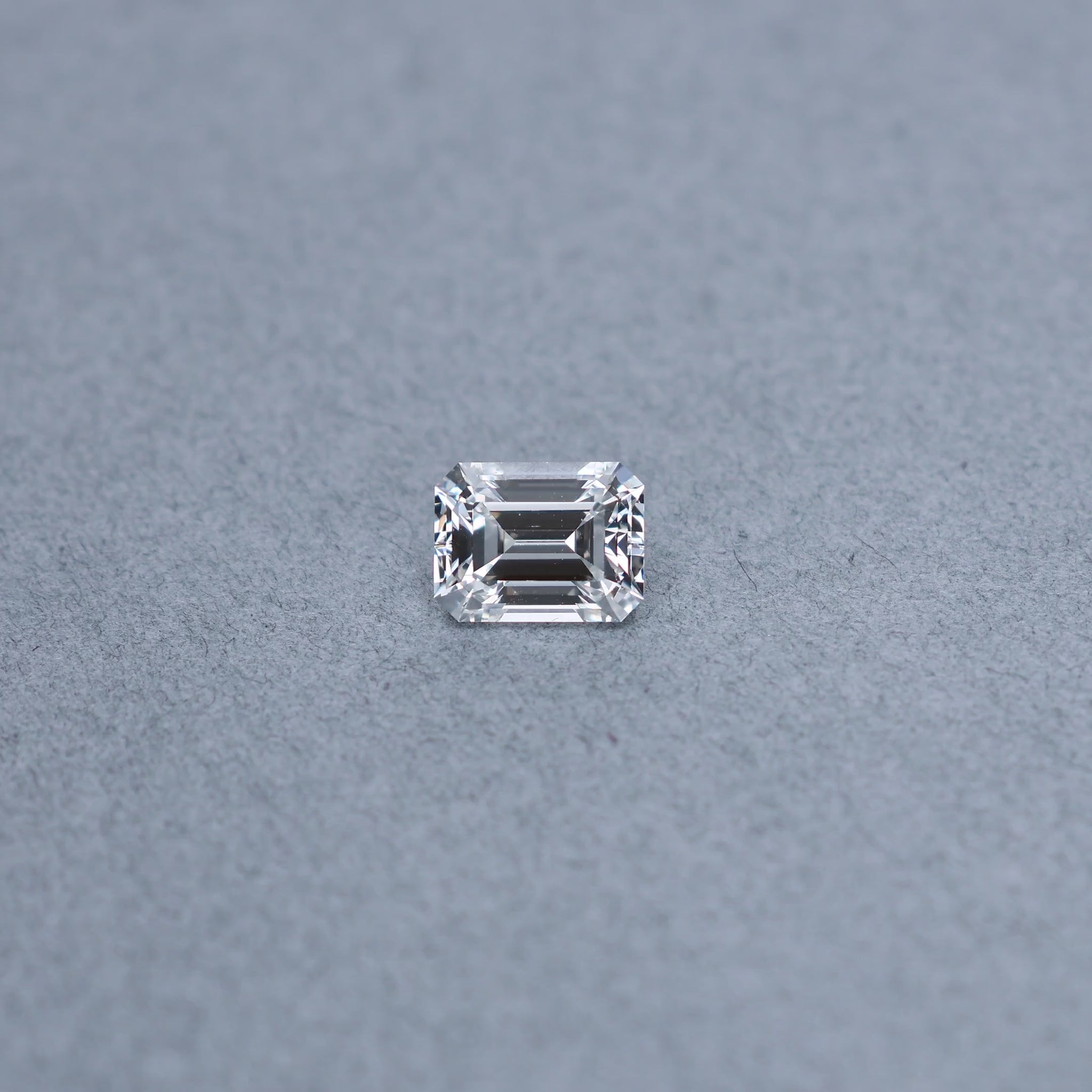 Emerald cut 2.02 carat GIA certified diamond graded EVS2 on a grey background