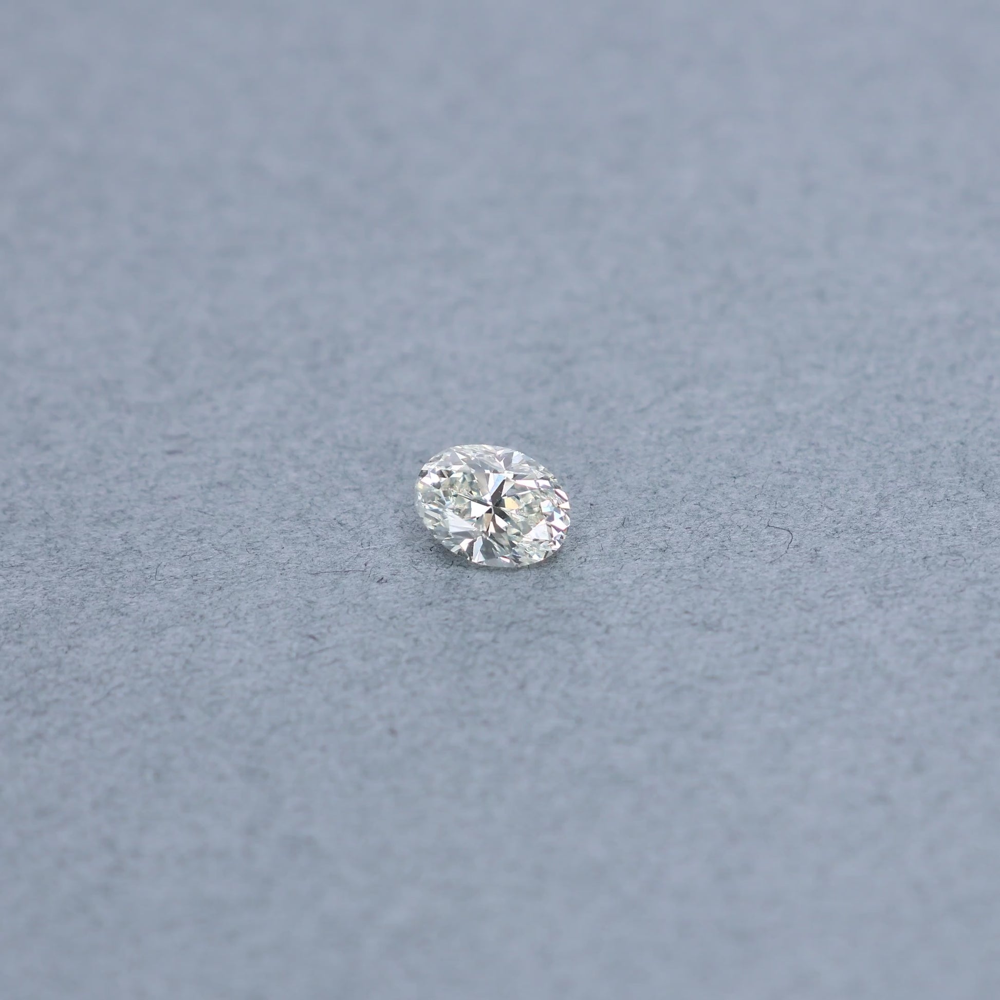 Oval 1.00 carat diamond graded KVS1 on a grey background
