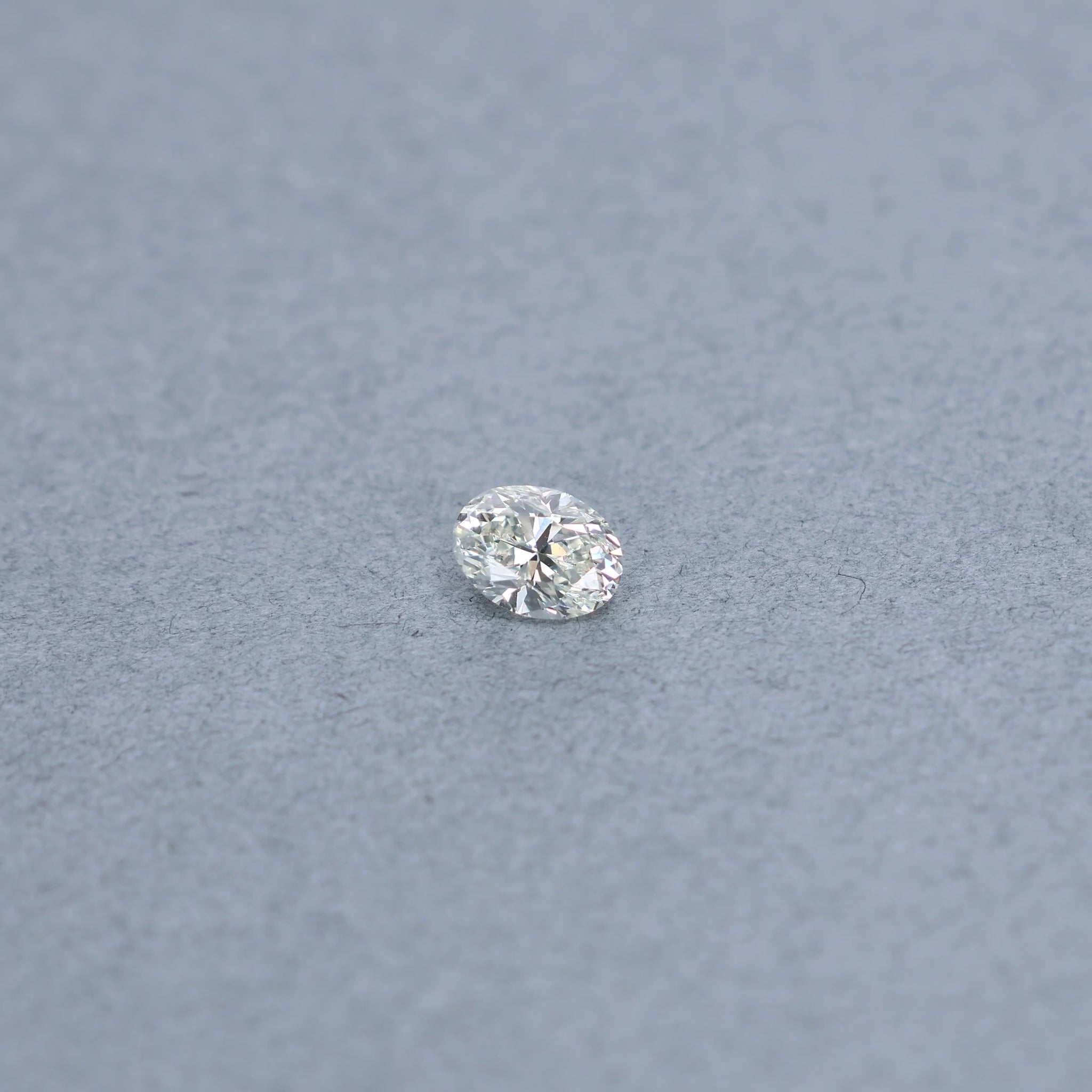 Oval 1.00 carat diamond graded KVS1 on a grey background