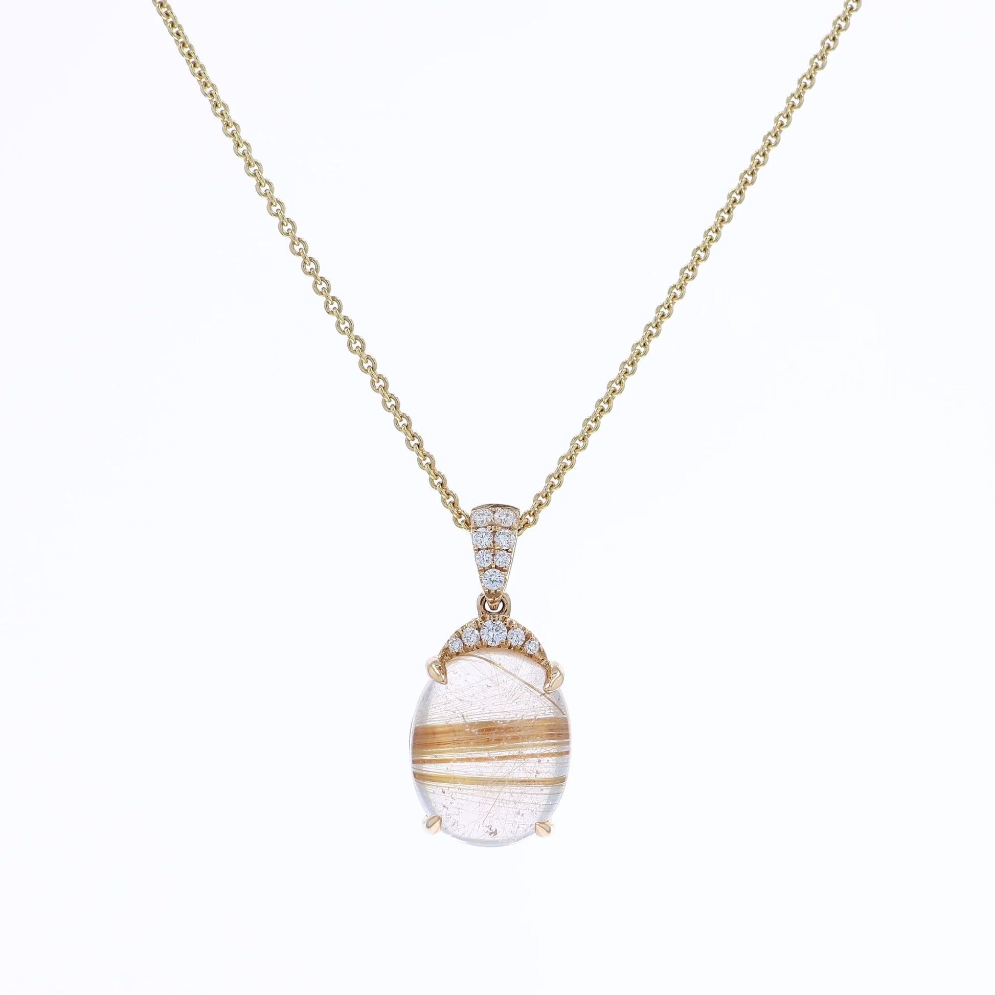Yellow gold oval rutilated quartz and diamond pendant necklace on a white background