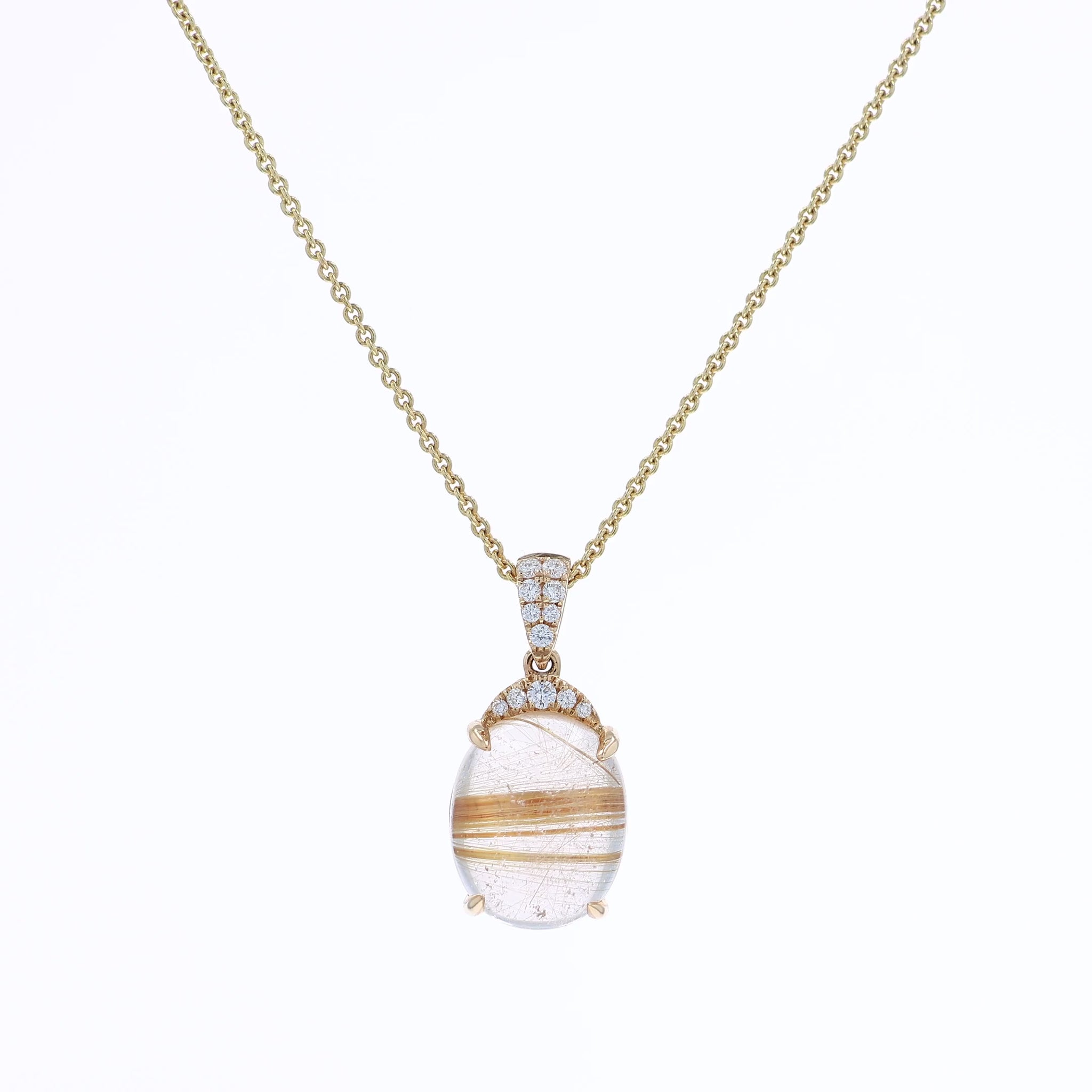 Yellow gold oval rutilated quartz and diamond pendant necklace on a white background