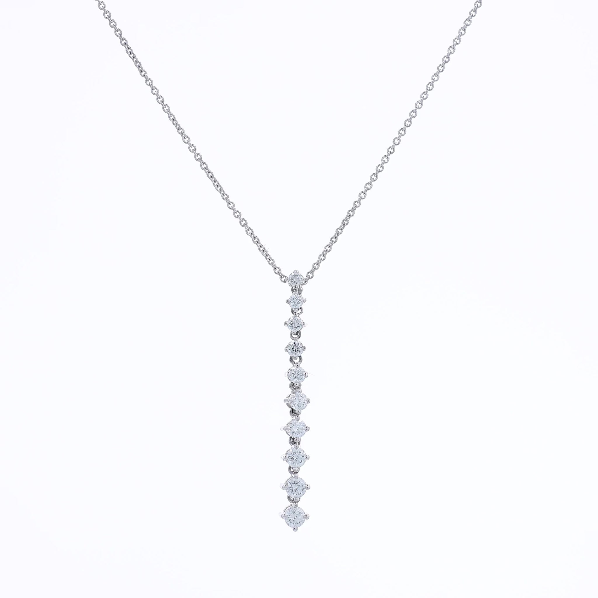 White gold single row graduated diamond pendant necklace on a white background