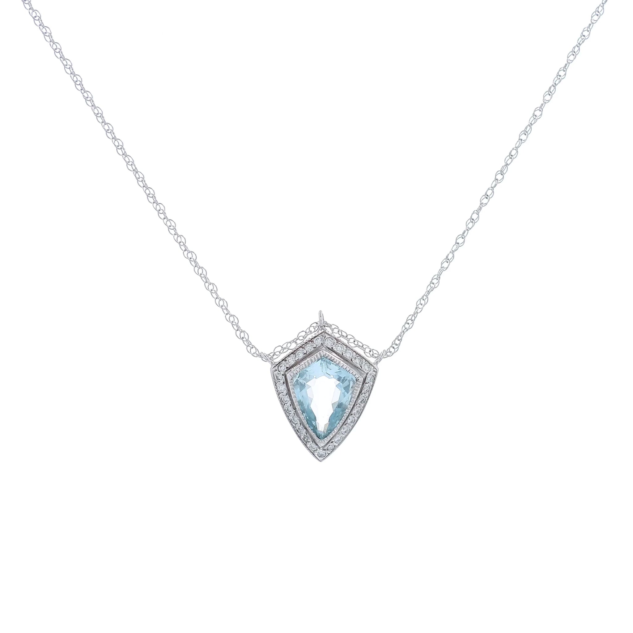 White gold shield cut aquamarine and diamond halo pendant necklace on a white background