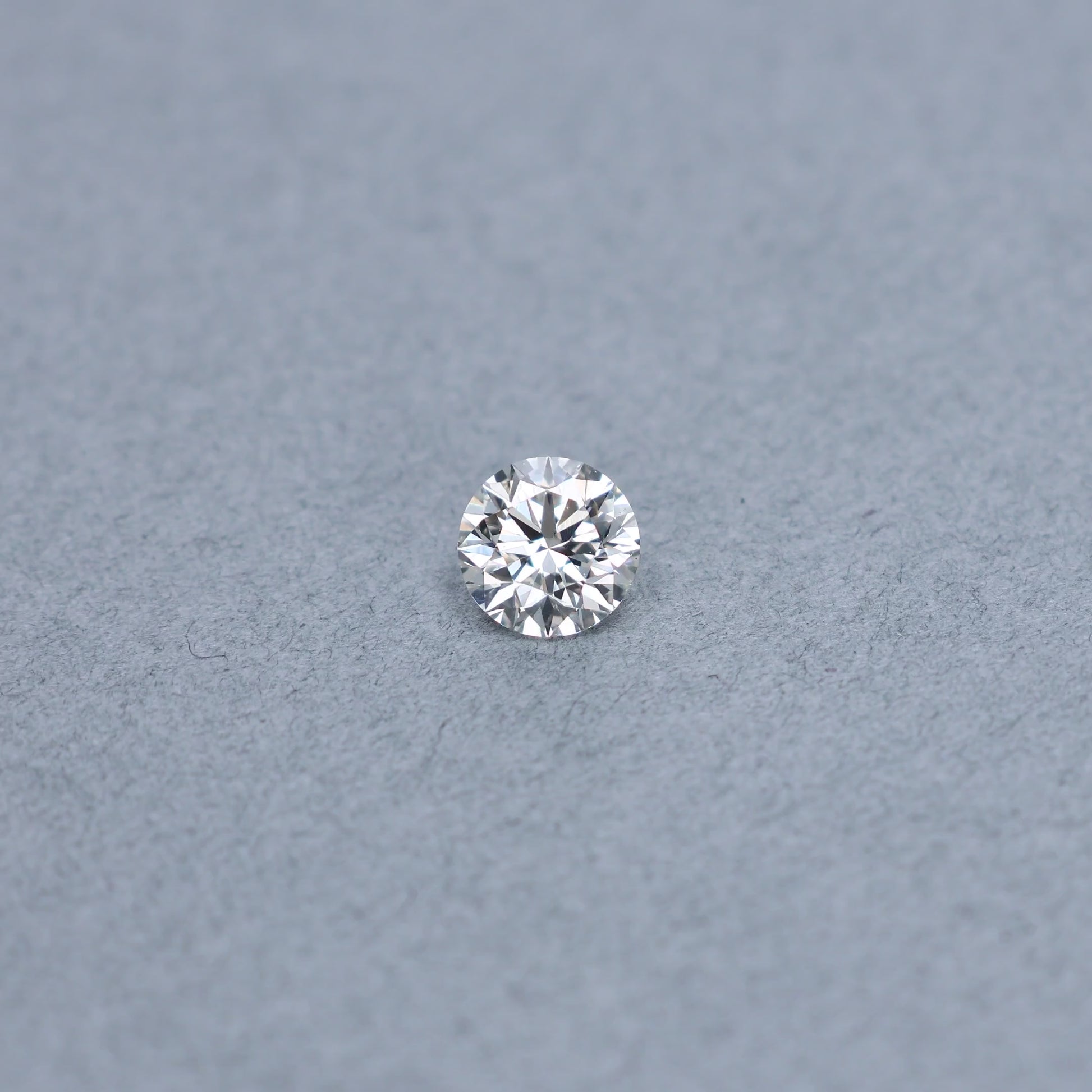 Round 1.54 carat GIA certified triple excellent diamond graded JSI1 on a grey background