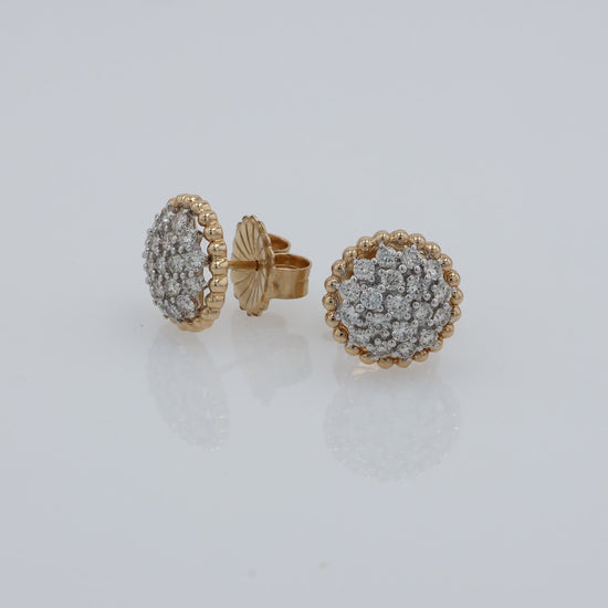 Video of A pair of round gold earrings with pavé-set clear stones, shown at various angles on a clean white background. 