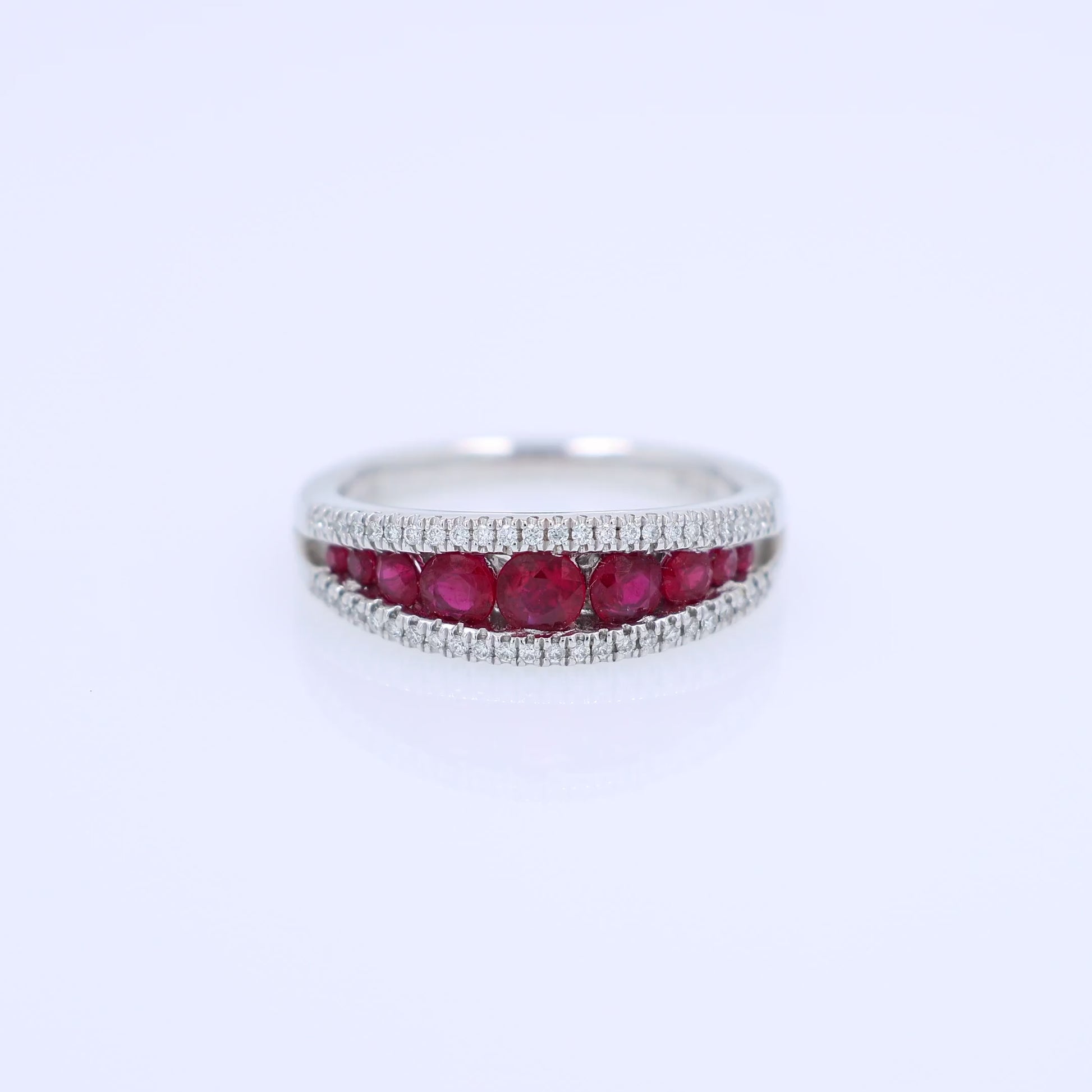 White gold ring with rubies and diamonds on a white background