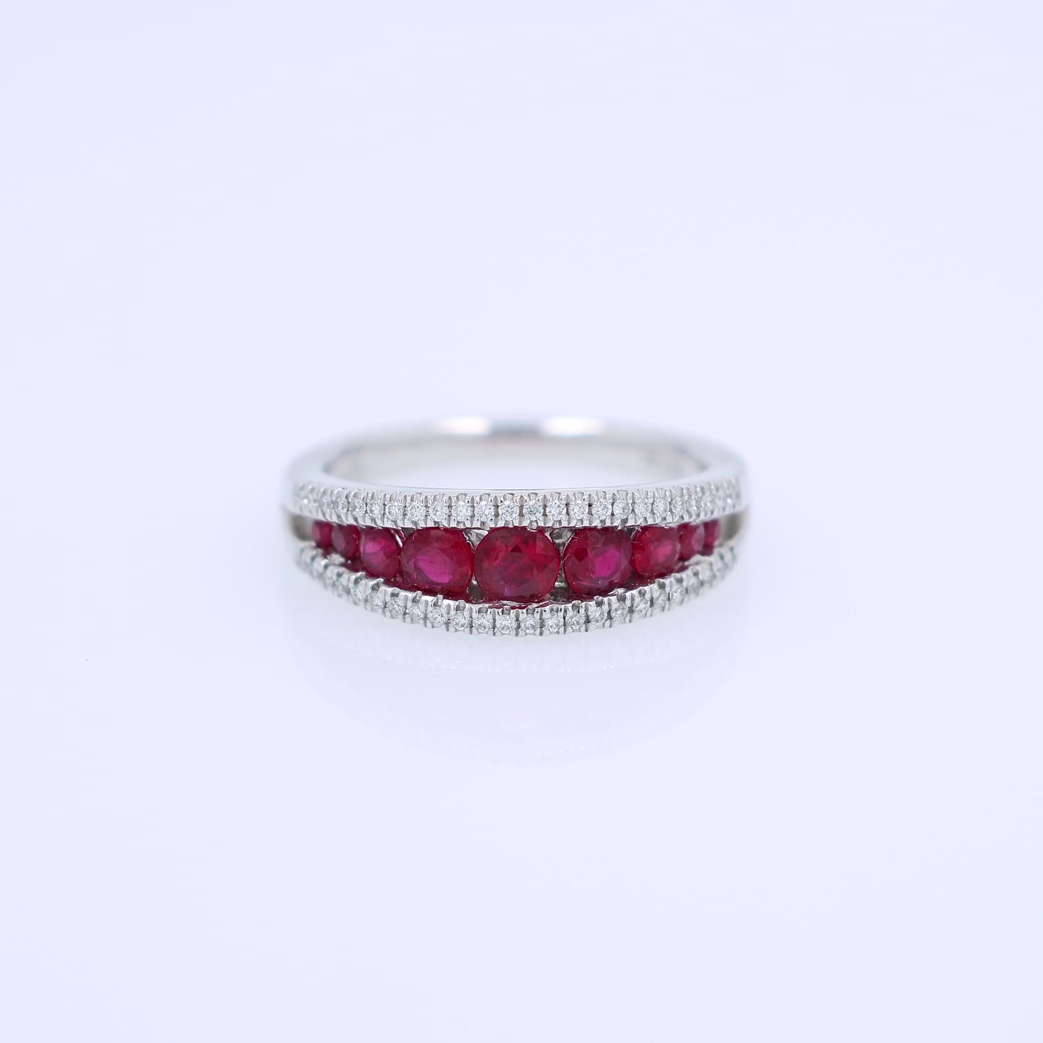 White gold ring with rubies and diamonds on a white background