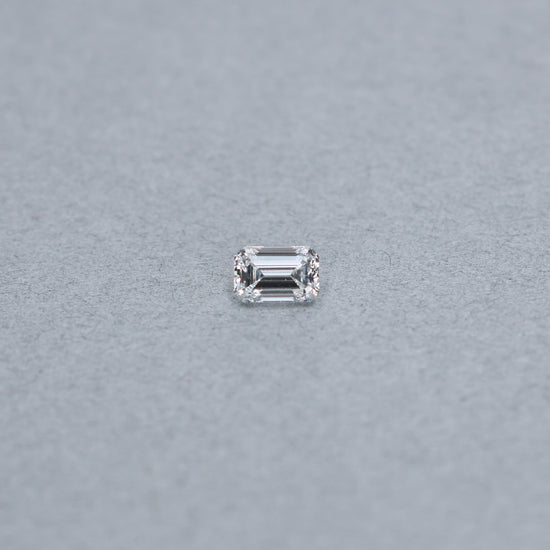 Emerald cut 1.02 carat GIA certified diamond graded FSI1 on a grey background