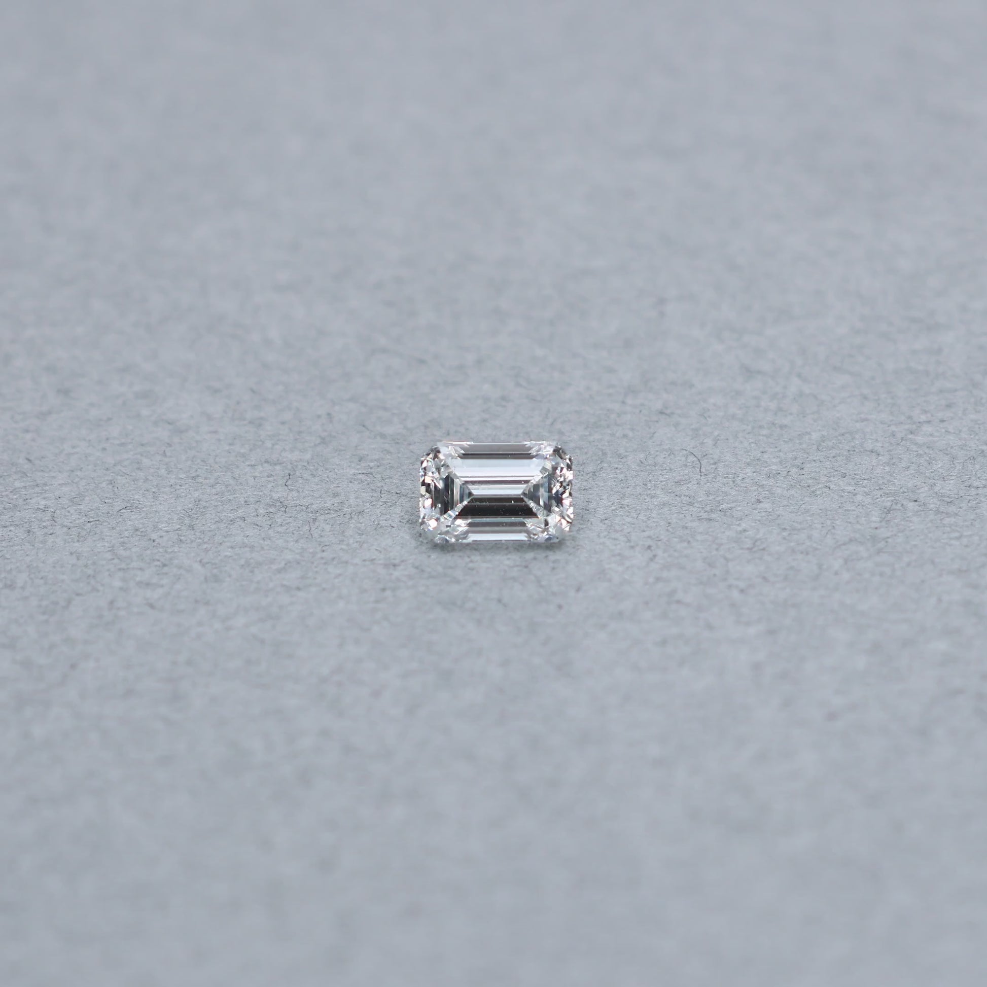 Emerald cut 1.02 carat GIA certified diamond graded FSI1 on a grey background