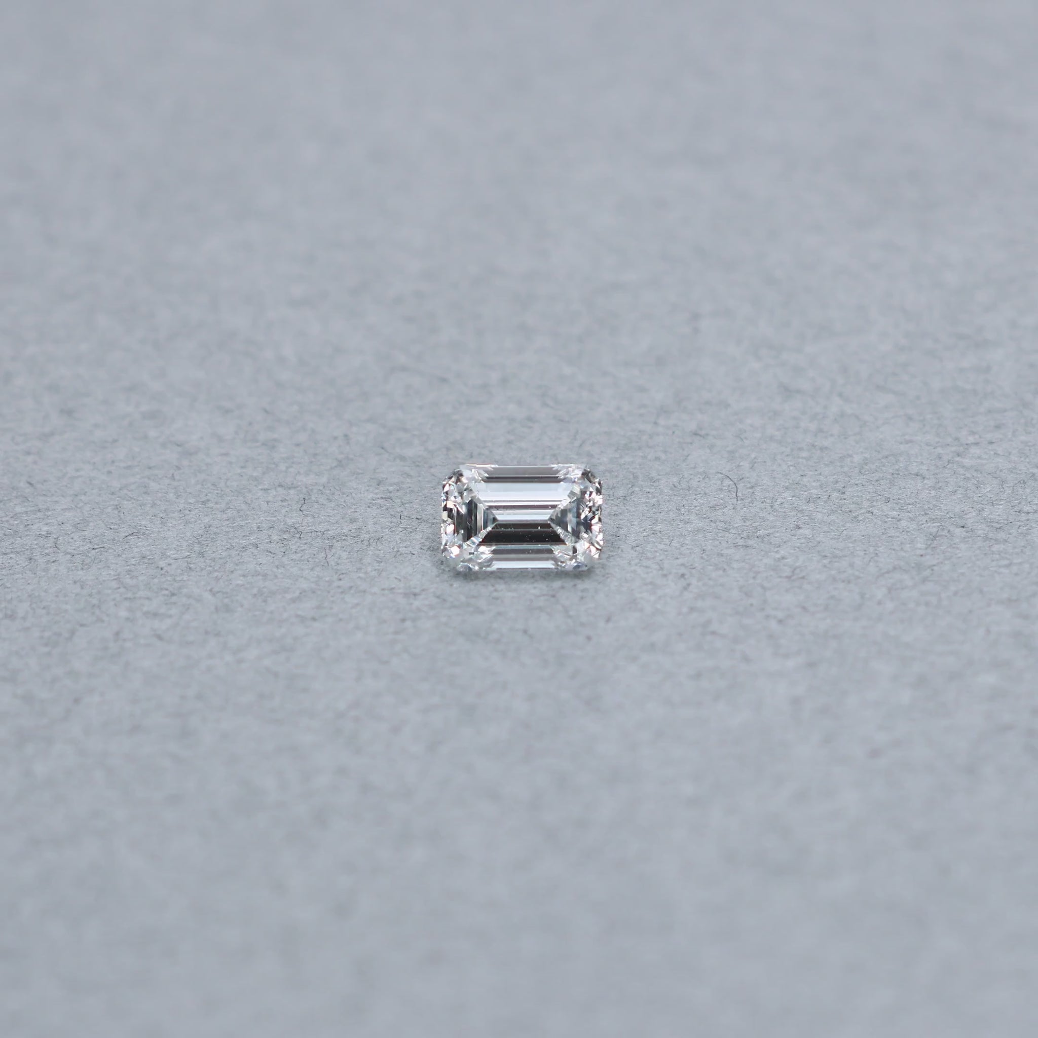Emerald cut 1.02 carat GIA certified diamond graded FSI1 on a grey background