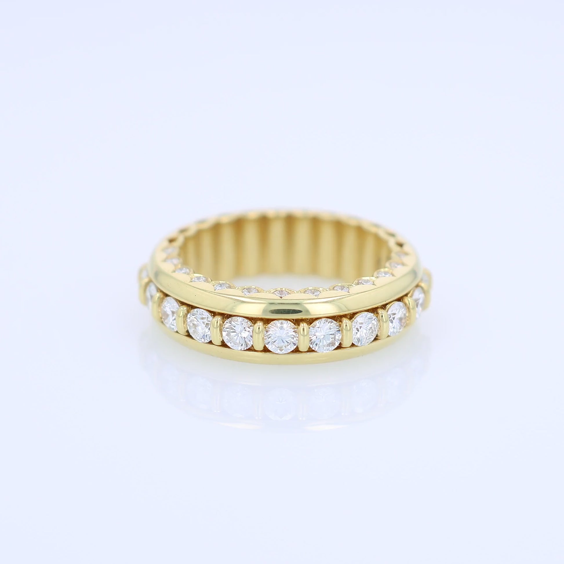 Yellow gold ring with diamond accents on a white background