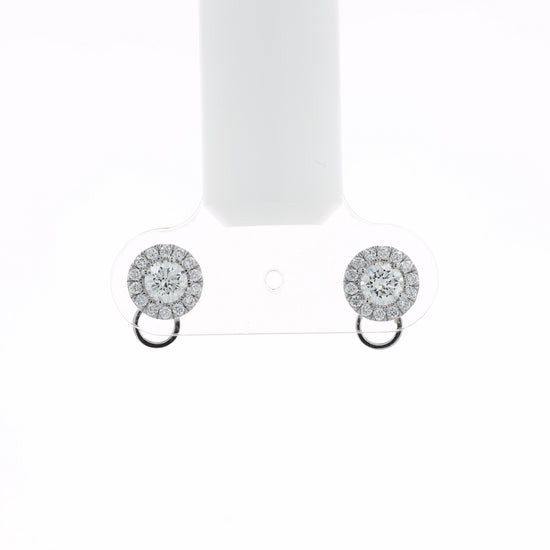 Video of a pair of round halo stud earrings with clear gemstones in a silver-toned setting and a small circular drop below, shown at various angles on a white background with soft reflections.