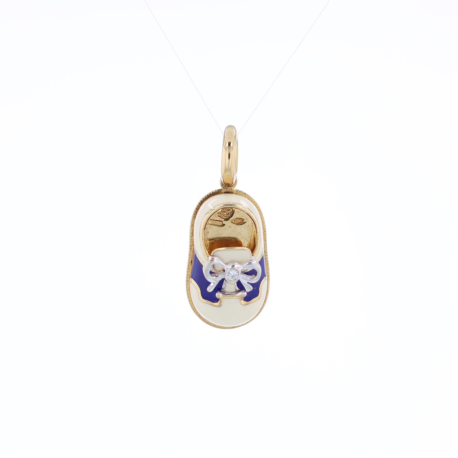 Yellow gold shoe charm pendant with  diamond on white gold bowtie on a white background