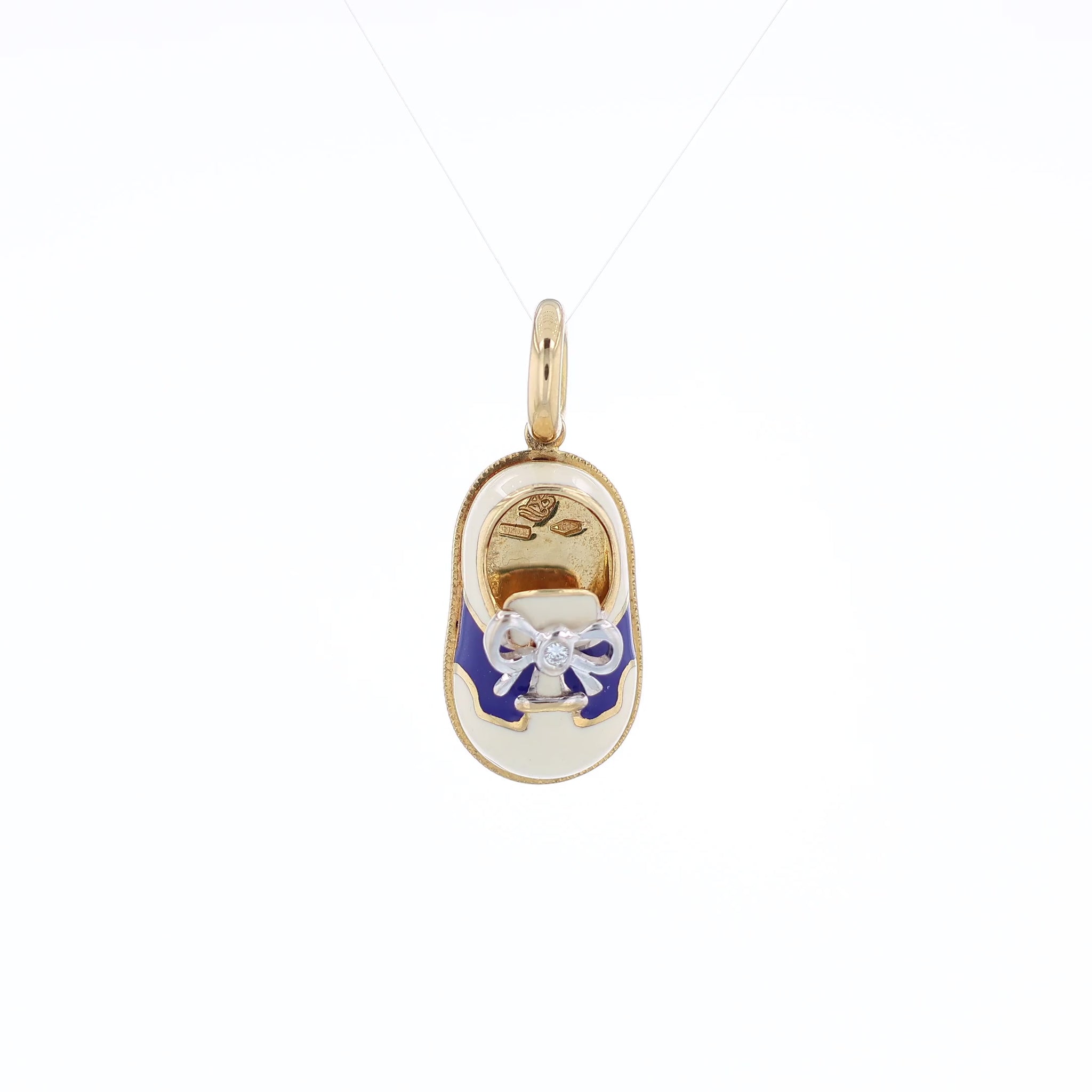 Yellow gold shoe charm pendant with  diamond on white gold bowtie on a white background