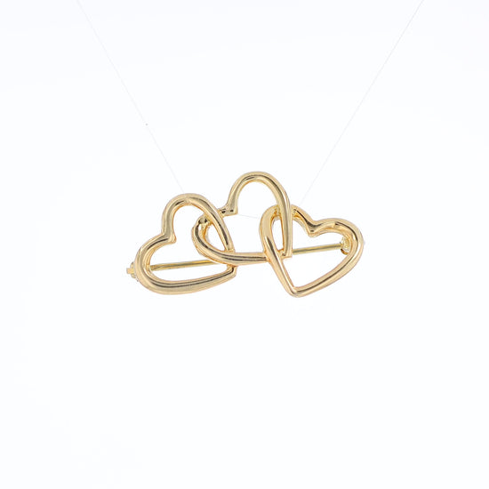 Yellow gold Tiffany & Co polished triple heart pin on a white background