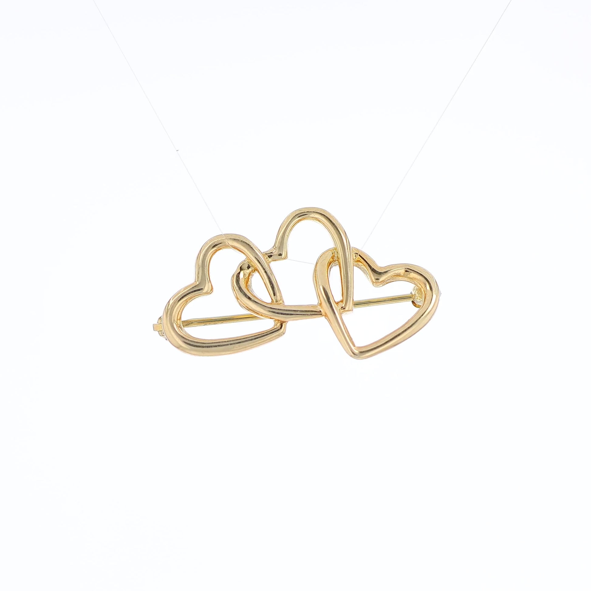 Yellow gold Tiffany & Co polished triple heart pin on a white background