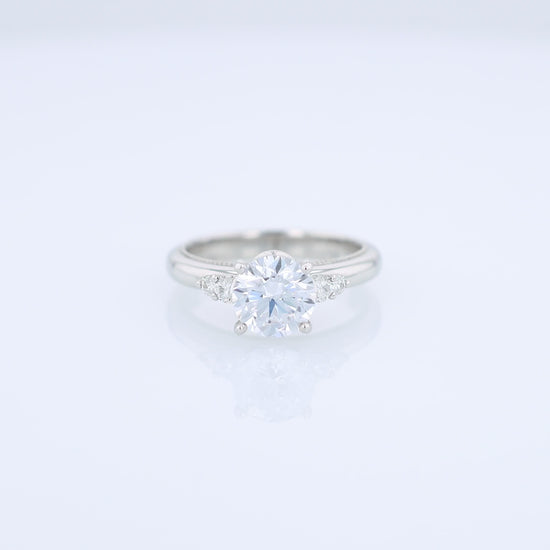Platinum diamond engagement ring with diamond accents and a round cubic zirconia center on a white background