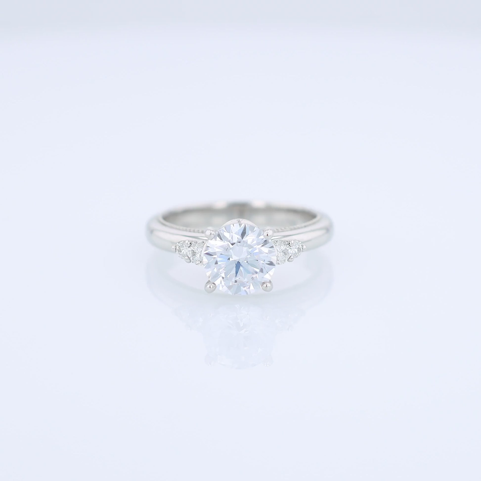 Platinum diamond engagement ring with diamond accents and a round cubic zirconia center on a white background