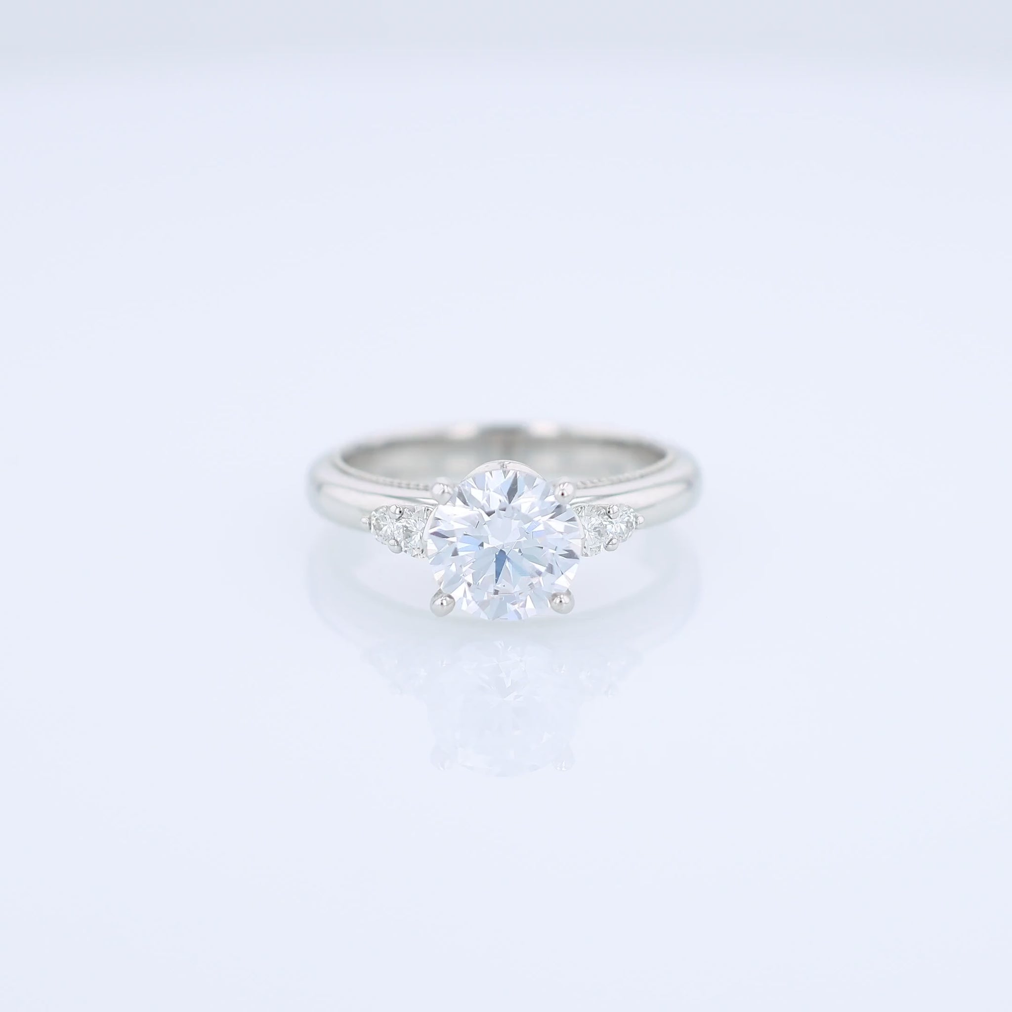 Platinum diamond engagement ring with diamond accents and a round cubic zirconia center on a white background