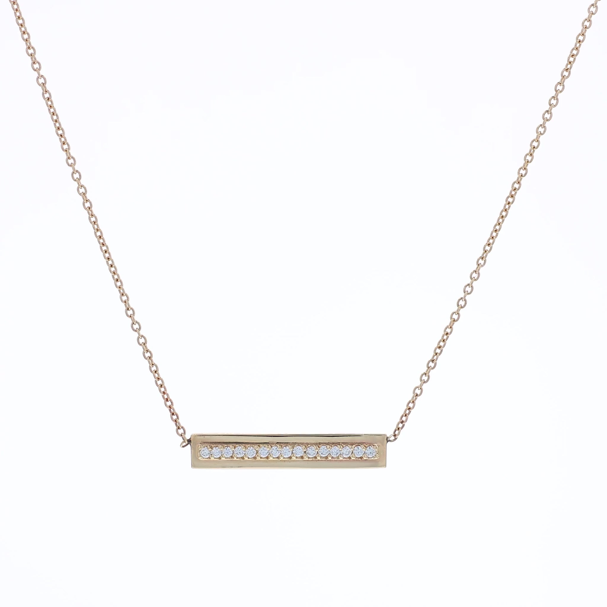 Yellow gold single row diamond bar pendant necklace on a white background
