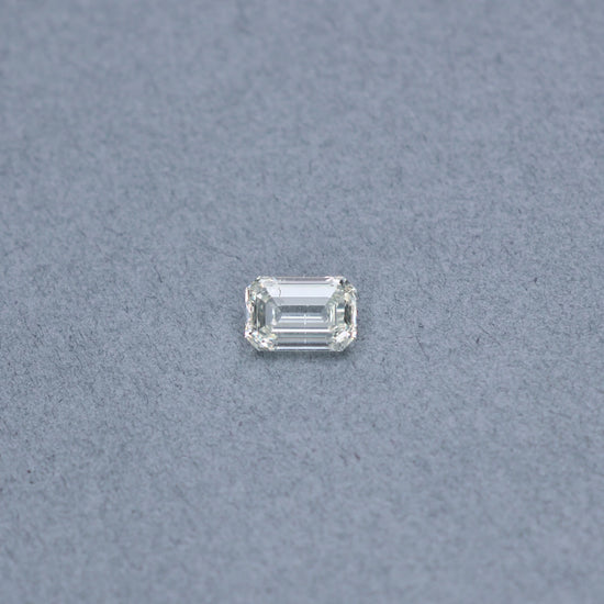 Emerald cut 2.01 carat GIA certified diamond graded KSI2 on a grey background