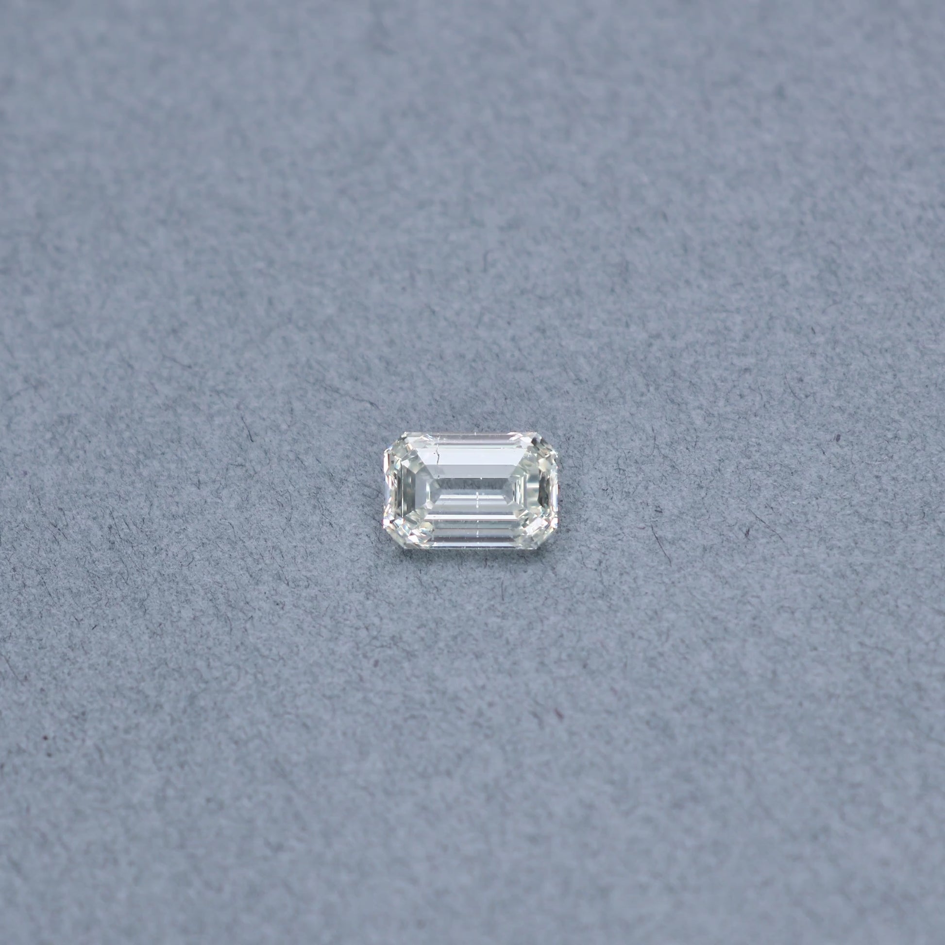 Emerald cut 2.01 carat GIA certified diamond graded KSI2 on a grey background
