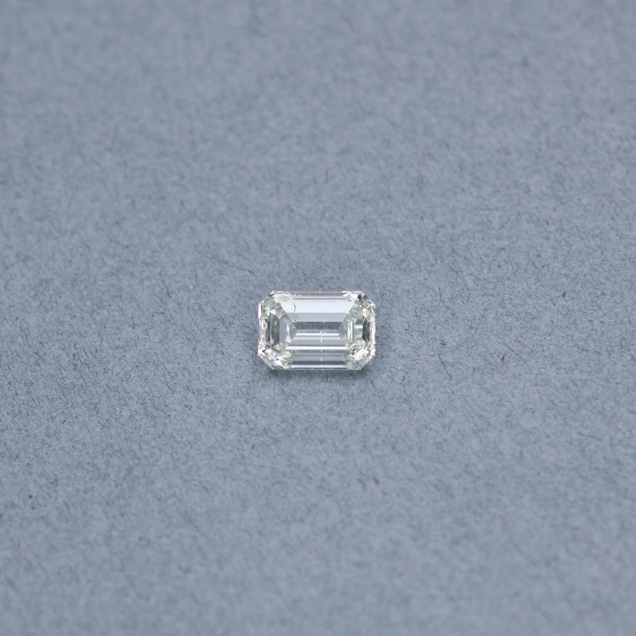 Emerald cut 2.01 carat GIA certified diamond graded KSI2 on a grey background