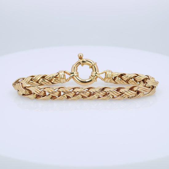 Gold braided bracelet on a white background