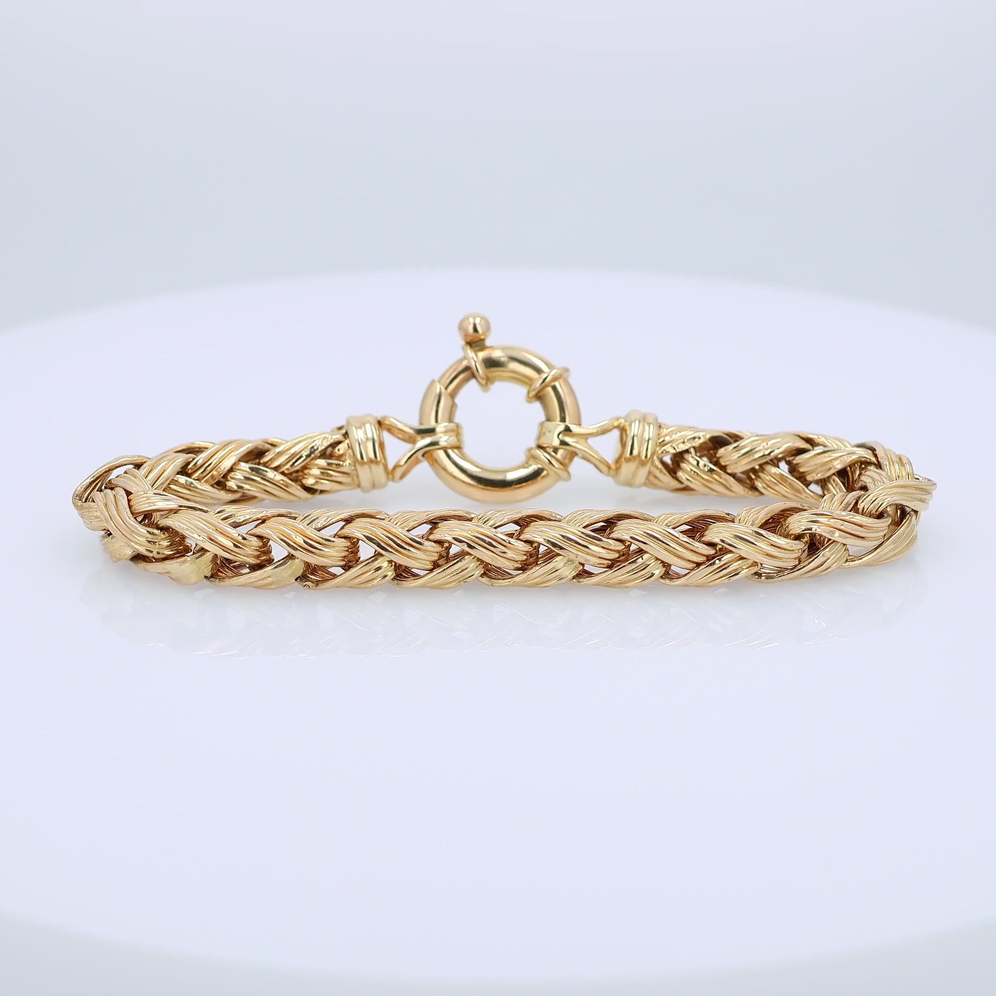 Gold braided bracelet on a white background