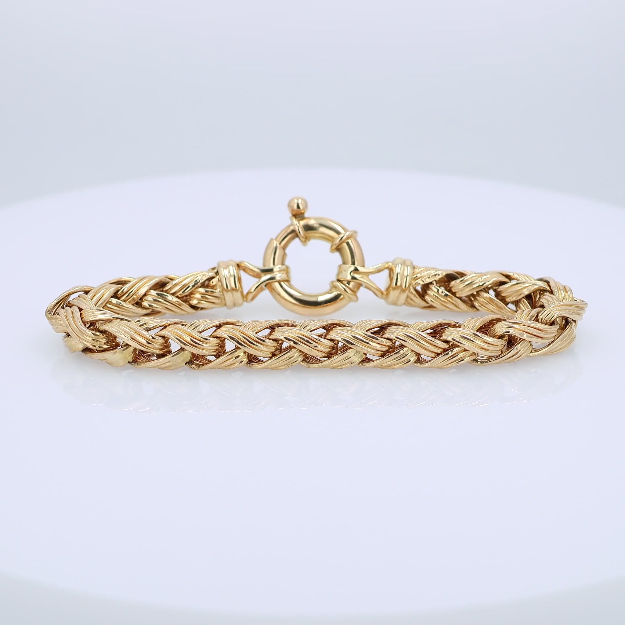 Gold braided bracelet on a white background