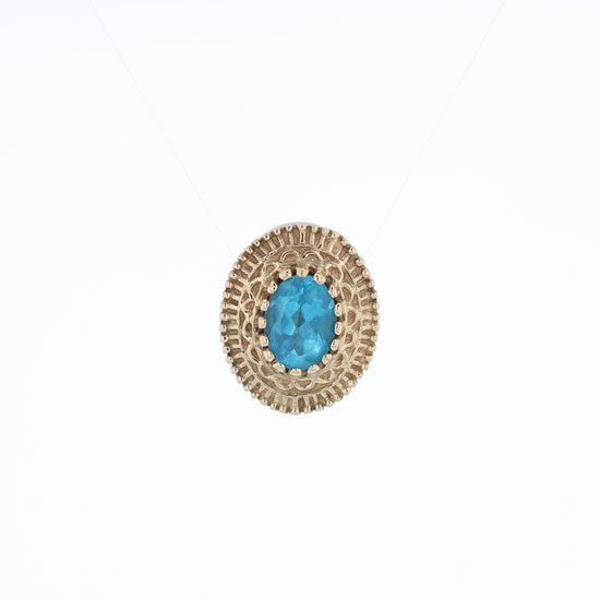 Yellow gold oval blue topaz slide charm pendant with a textured front on a white background