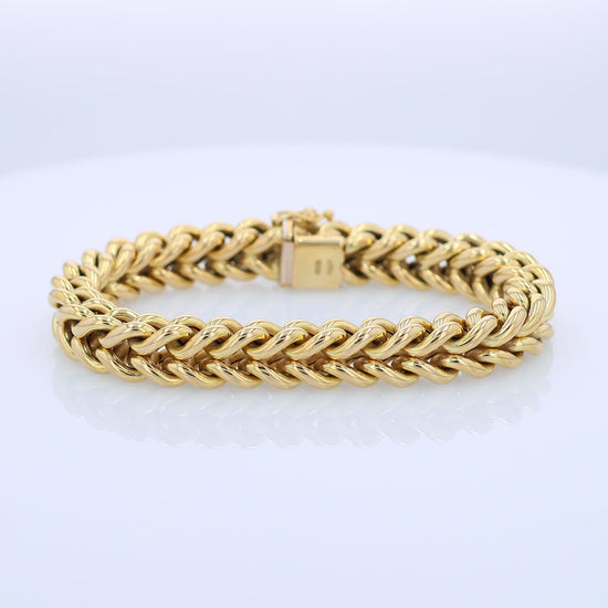 Yellow gold braided link chain bracelet on a white background