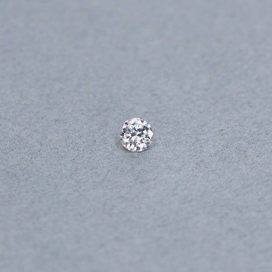 Round .63 carat diamond graded FSI1 on a grey background