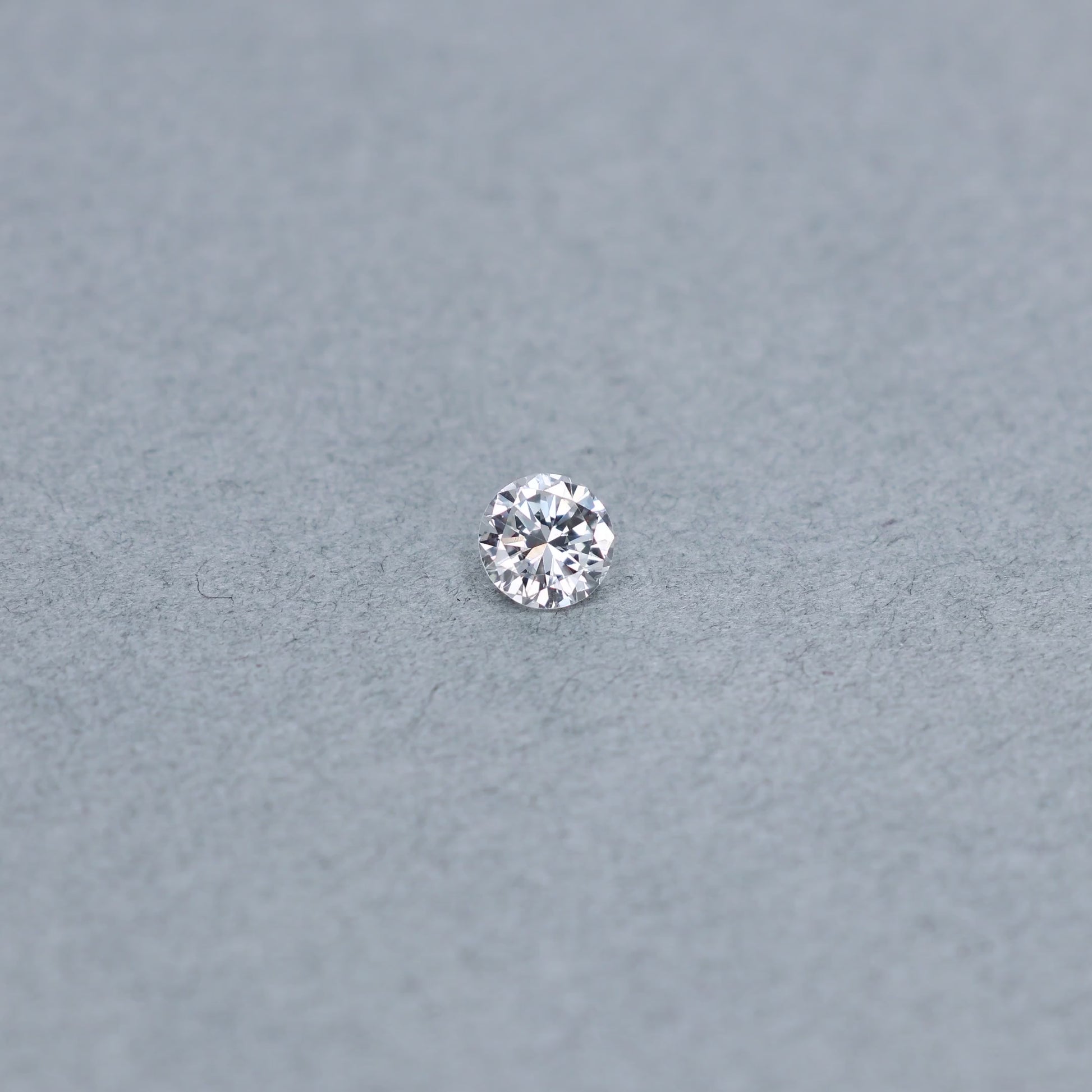 Round .63 carat diamond graded FSI1 on a grey background