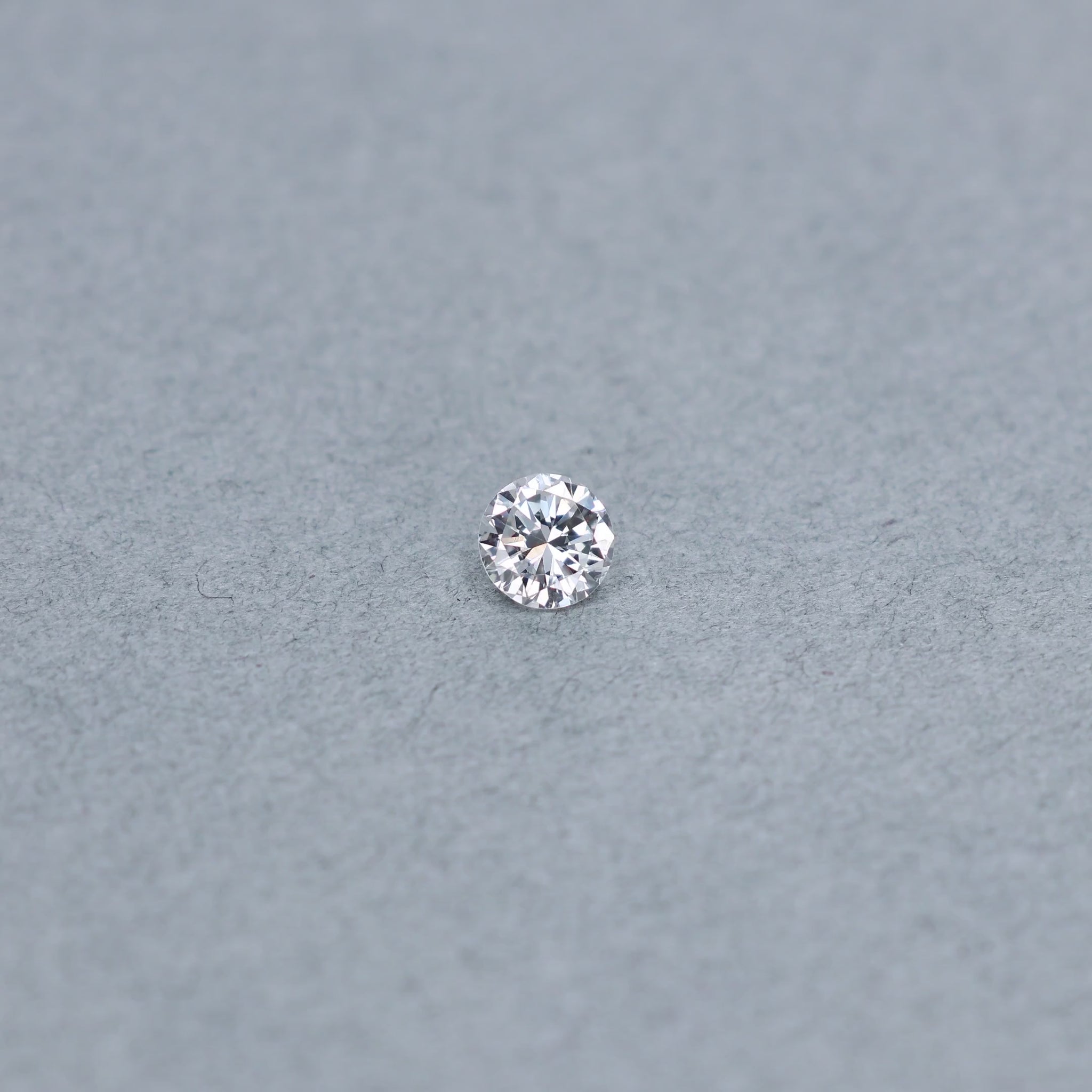 Round .63 carat diamond graded FSI1 on a grey background