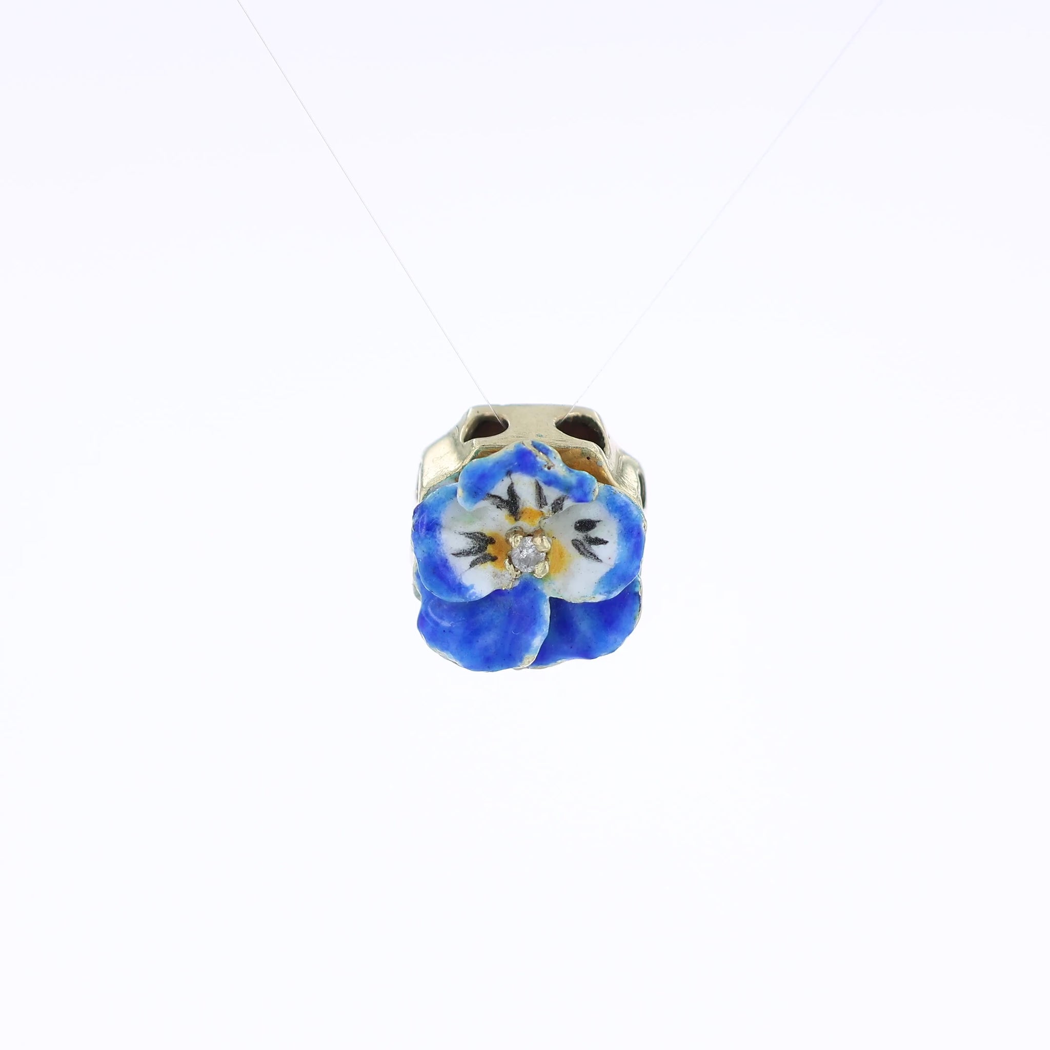 Yellow gold slide pendant with a multi-color enamel and diamond flower in front on a white background