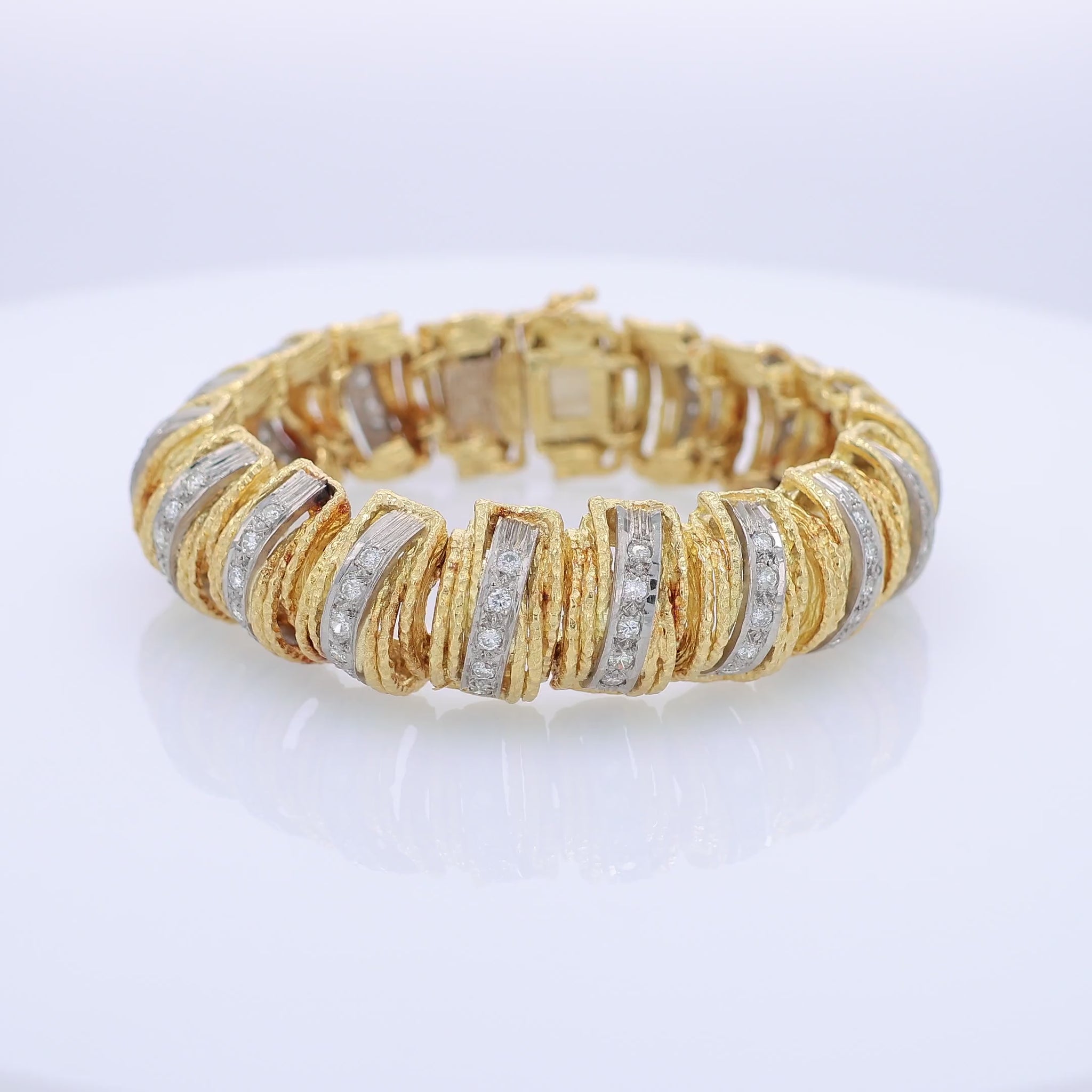 360 degree video of a textured two-tone gold bracelet with diamonds on a white background