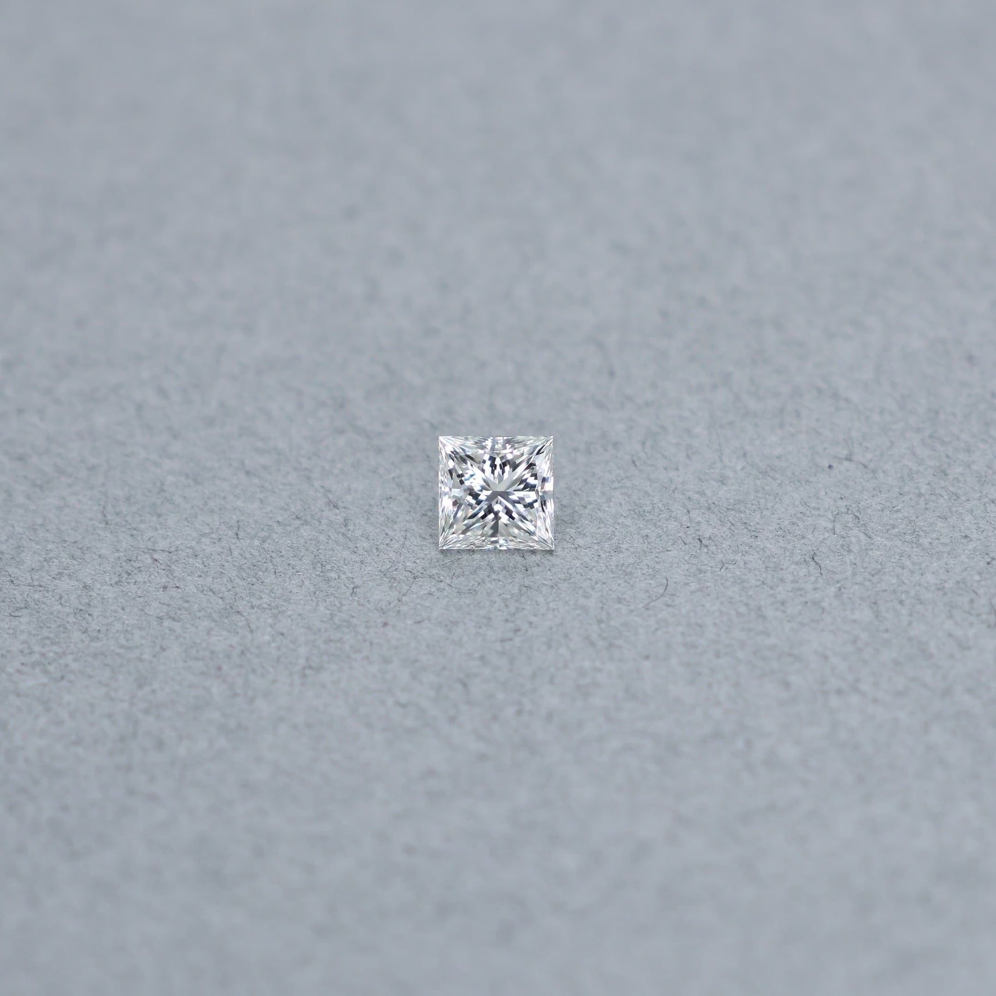 Princess cut 0.81 carat GIA certified diamond graded H IF on a grey background