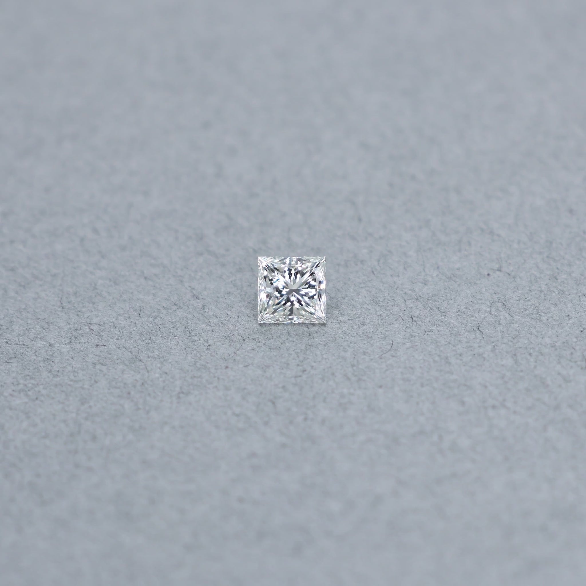 Princess cut 0.81 carat GIA certified diamond graded H IF on a grey background